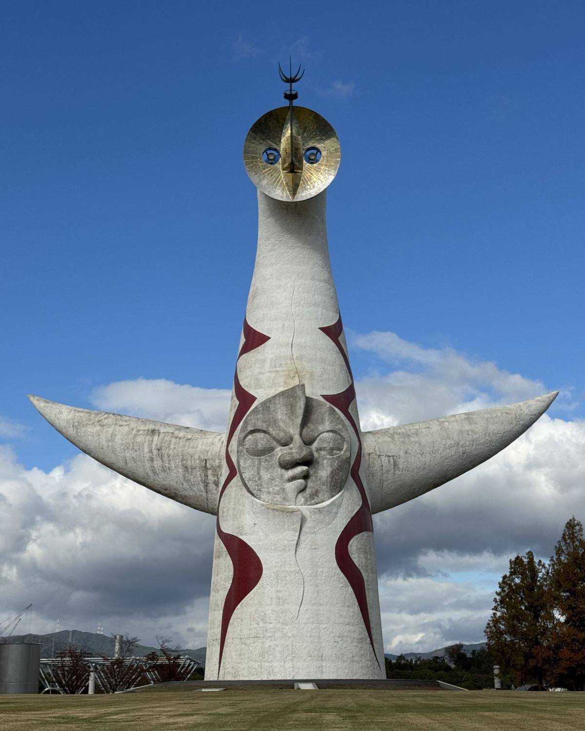 Front view of the iconic Tower of the Sun (Taiyo no To) sculpture designed by Taro Okamoto at Expo '70 Commemorative Park in Osaka, Japan.
